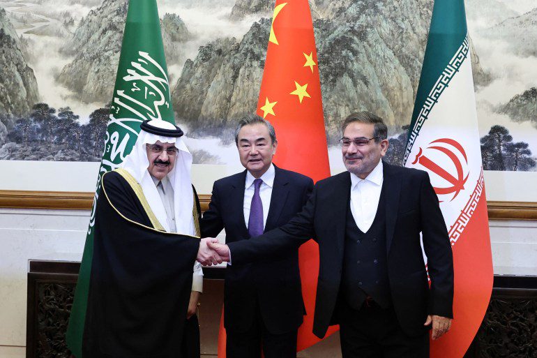 O chinês Wang Yi, o iraniano Ali Shamkhani e o saudita Musaed bin Mohammed Al-Aiban tiram fotos durante uma reunião em Pequim, China, em 10 de março de 2023.