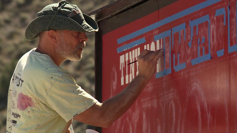 Um trabalhador repinta uma placa em preparação para um evento de eclipse solar.  (TV KSL, Mark Wetzel) 