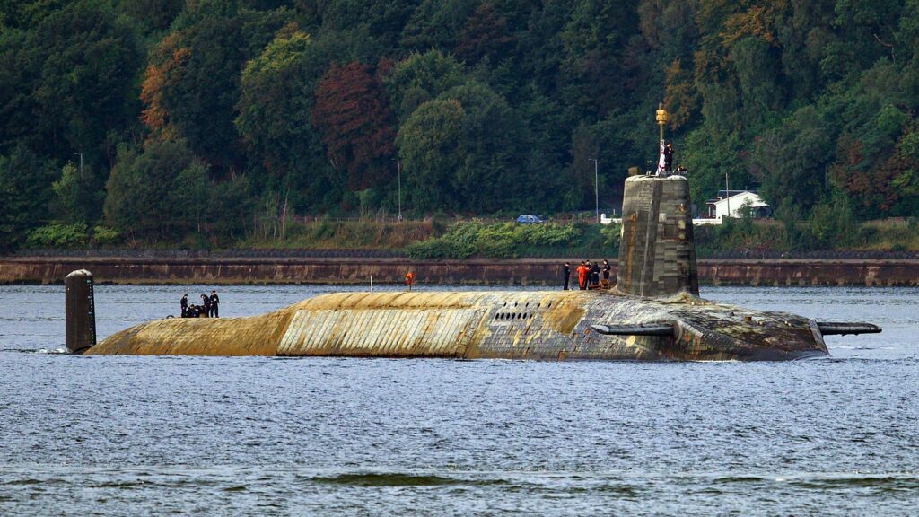 O submarino Vanguard chega em casa completamente submerso em algas