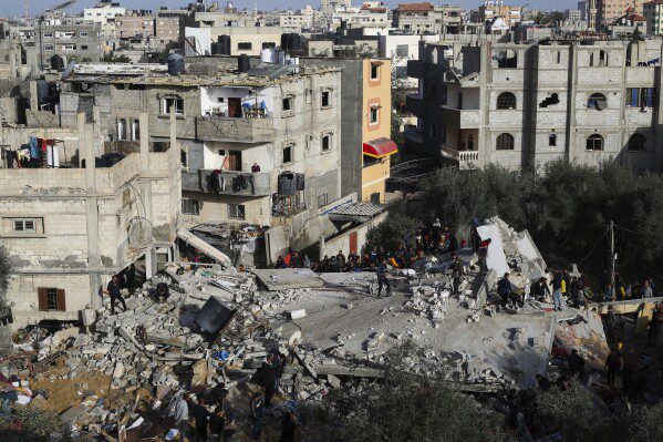 Palestinos observam a destruição após um ataque israelense a um prédio residencial em Rafah, Faixa de Gaza, domingo, 3 de março de 2024. (AP Photo/Hatem Ali)