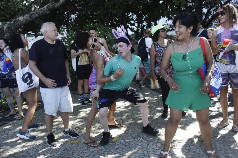 Os fãs de Madonna dançam do lado de fora do Copacabana Palace Hotel, onde Madonna está hospedada, antes de seu show no Rio de Janeiro, Brasil, na sexta-feira, 3 de maio de 2024. Madonna encerrará sua turnê no sábado com um show gratuito na praia de Copacabana.  (AP Photo/Bruna Prado