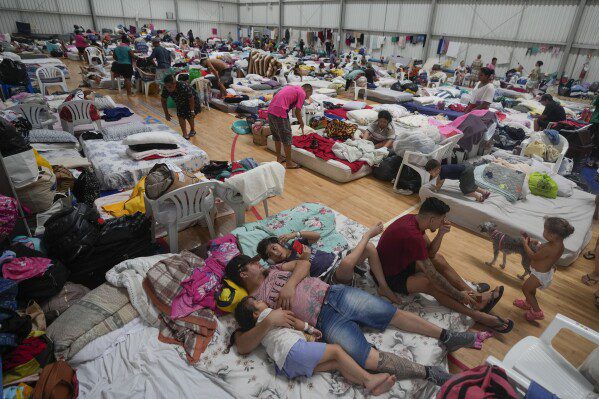 Moradores descansam em abrigo temporário para pessoas cujas casas foram inundadas por fortes chuvas, em Canoas, Rio Grande do Sul, Brasil, quarta-feira, 8 de maio de 2024. (AP Photo/Carlos Macedo)