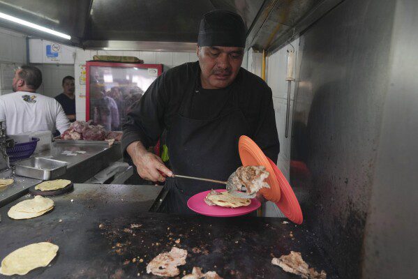 O recém-premiado chef com estrela Michelin Arturo Rivera Martinez prepara um pedido de tacos na barraca de tacos Tacos El Califa de León na Cidade do México, quarta-feira, 15 de maio de 2024. Tacos El Califa de León é a primeira barraca de tacos a receber um prêmio de estrela Michelin do guia alimentar francês.  (Foto AP/Fernando Llano)