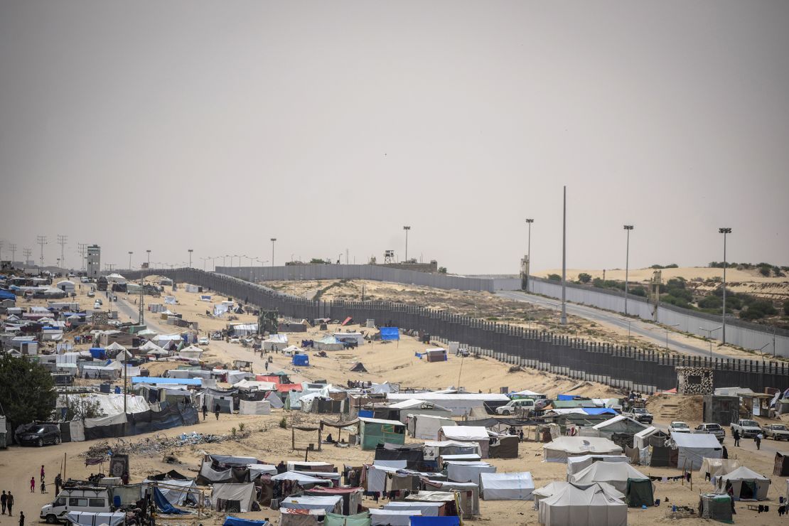 Palestinos deslocados pelo ataque aéreo e terrestre israelense à Faixa de Gaza caminham por um campo improvisado em Rafah, na fronteira com o Egito, em Gaza, em 10 de maio.