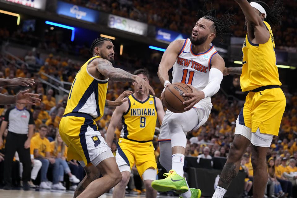 O armador do New York Knicks, Jalen Brunson, 11, dirige para a cesta passando pelo atacante do Indiana Pacers, Obi Toppin, à esquerda, durante a primeira metade do jogo 6 da segunda rodada da série de playoffs da NBA, sexta-feira, 17 de maio de 2024, em Indianápolis.  (Foto AP/Michael Conroy)