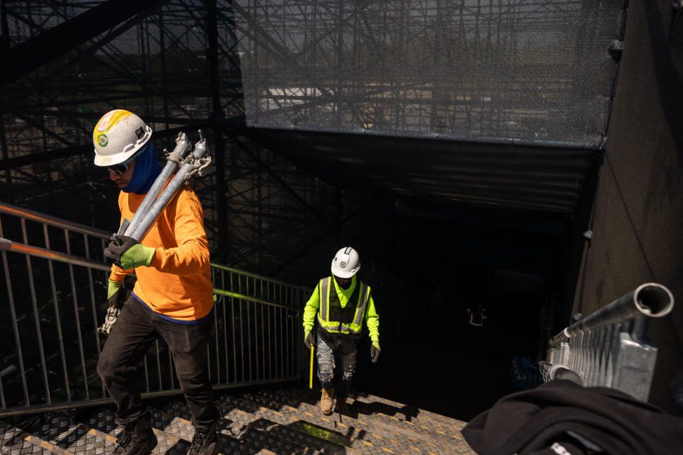 Trabalhadores da construção civil carregam equipamentos enquanto constroem o Estádio Internacional de Críquete do Condado de Nassau para a próxima Copa do Mundo T20 Masculina da ICC em Eisenhower Park, em East Meadow, em 1º de maio de 2024, em Nova York.  O Nassau County International Cricket Stadium está em construção no Eisenhower Park em East Meadow, Nova York, antes da Copa do Mundo ICC T20 de 2024. O recém-construído Nassau County International Cricket Stadium, perto de Nova York, foi inaugurado em 15 de maio de 2024 com a Sports. Mundo Corporal 