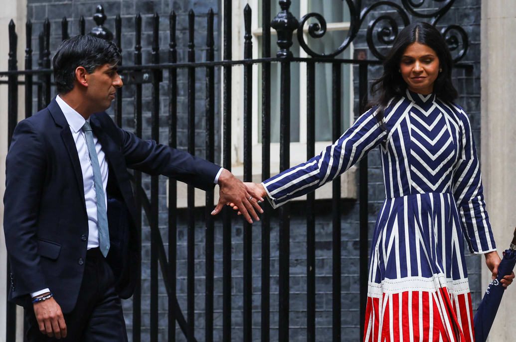 O primeiro-ministro britânico cessante, Rishi Sunak, segura a mão de sua esposa Akshata Murty enquanto eles saem da residência de Downing Street.