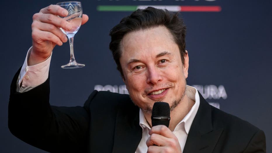 Elon Musk levanta uma taça para comemorar